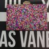 Bolso de fiesta con pedrería multicolor y filo y espalda dorada.