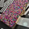 Bolso de fiesta con pedrería multicolor y filo y espalda dorada.