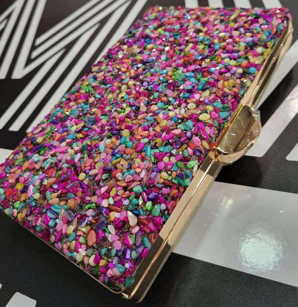 Bolso de fiesta con pedrería multicolor y filo y espalda dorada.