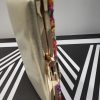 Bolso de fiesta con pedrería multicolor y filo y espalda dorada.